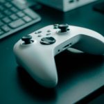 Close-up of a white game controller on a sleek desk, highlighting technology and gaming.